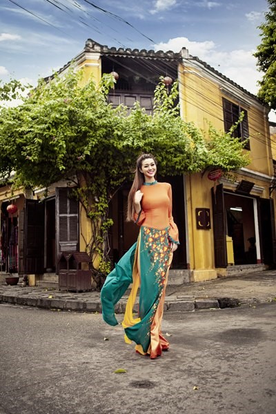 オレンジのアオザイを着たベトナム人女性
